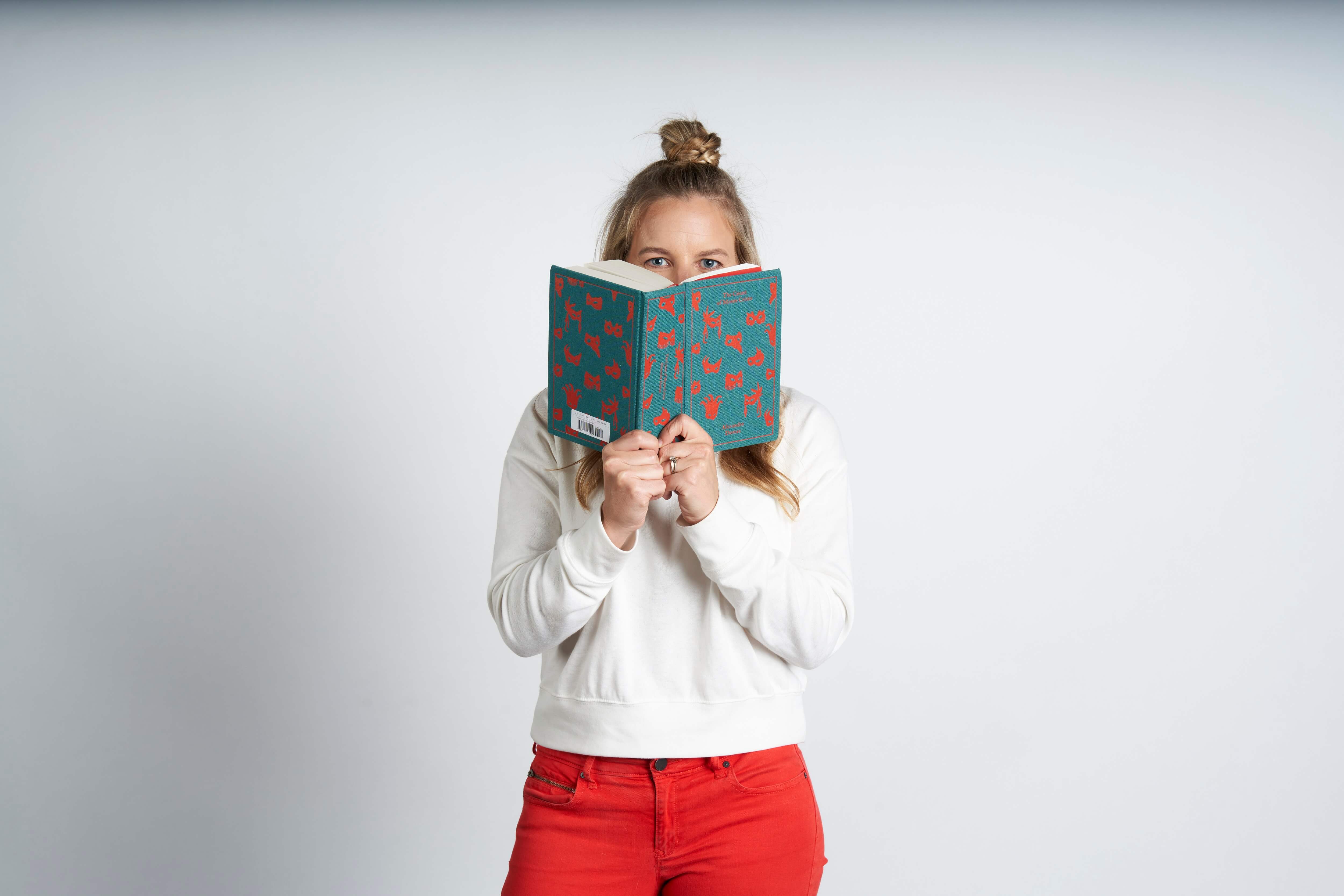woman peaking from behind book