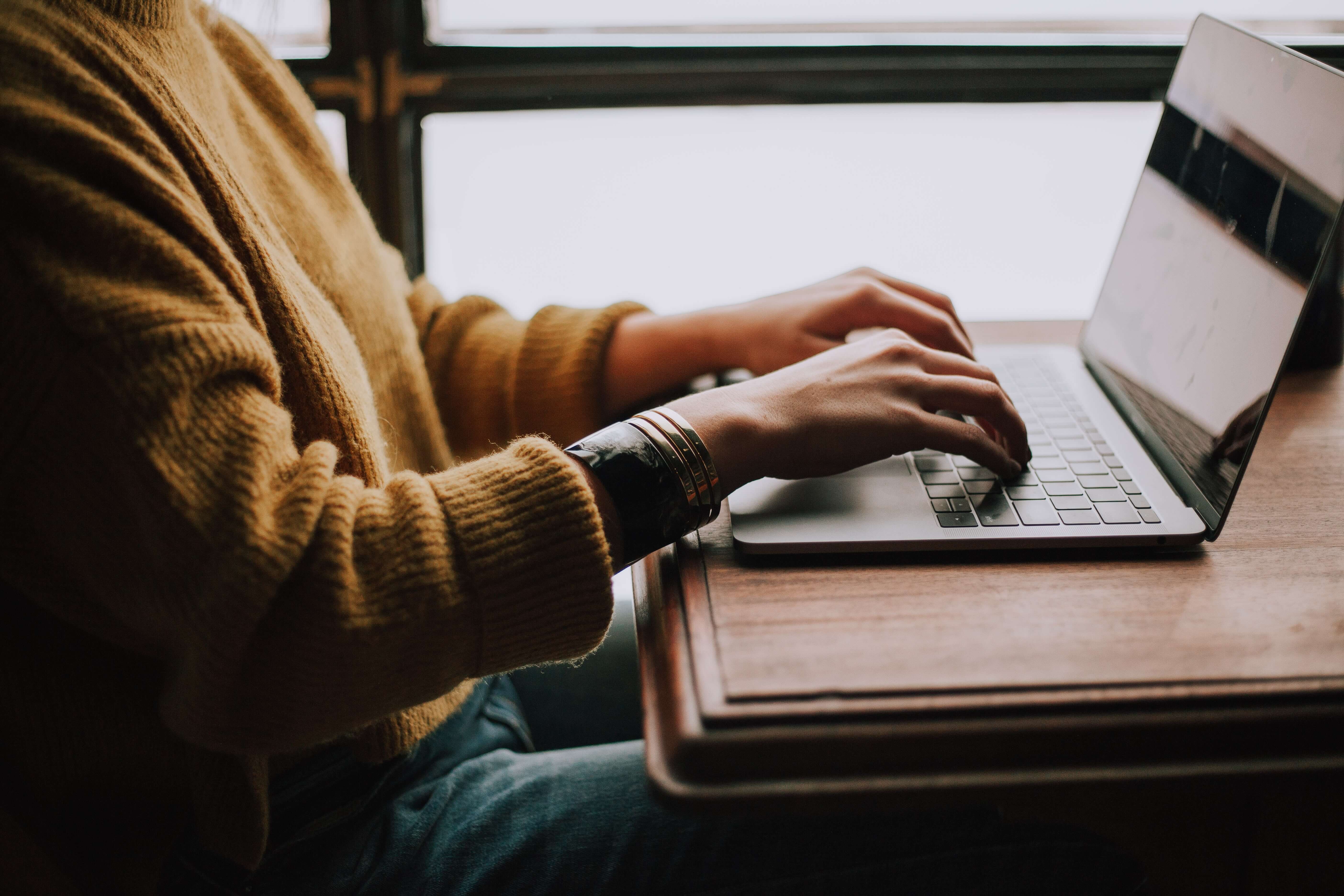 person sitting and typing on laptop
