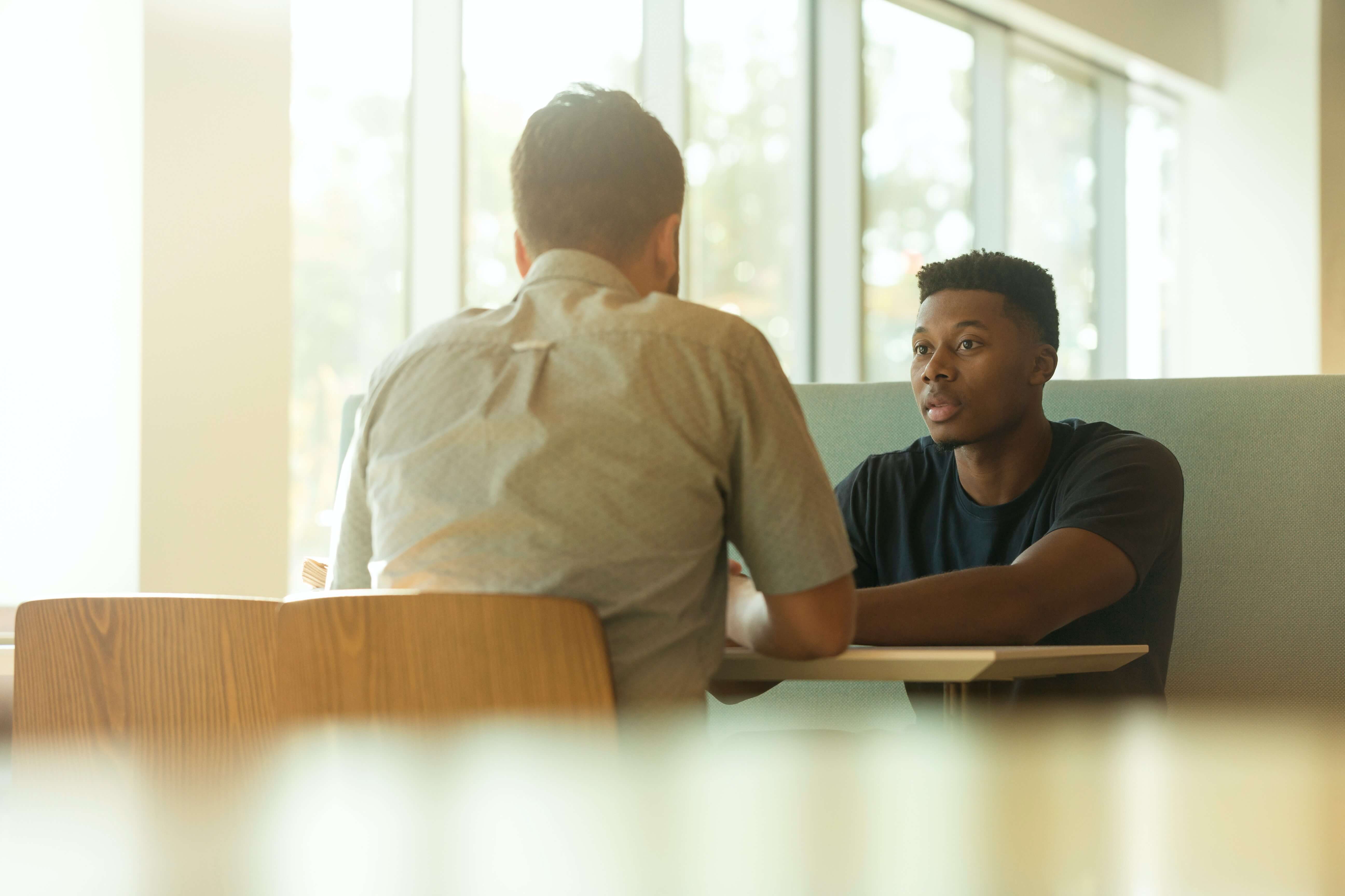two men talking at a table