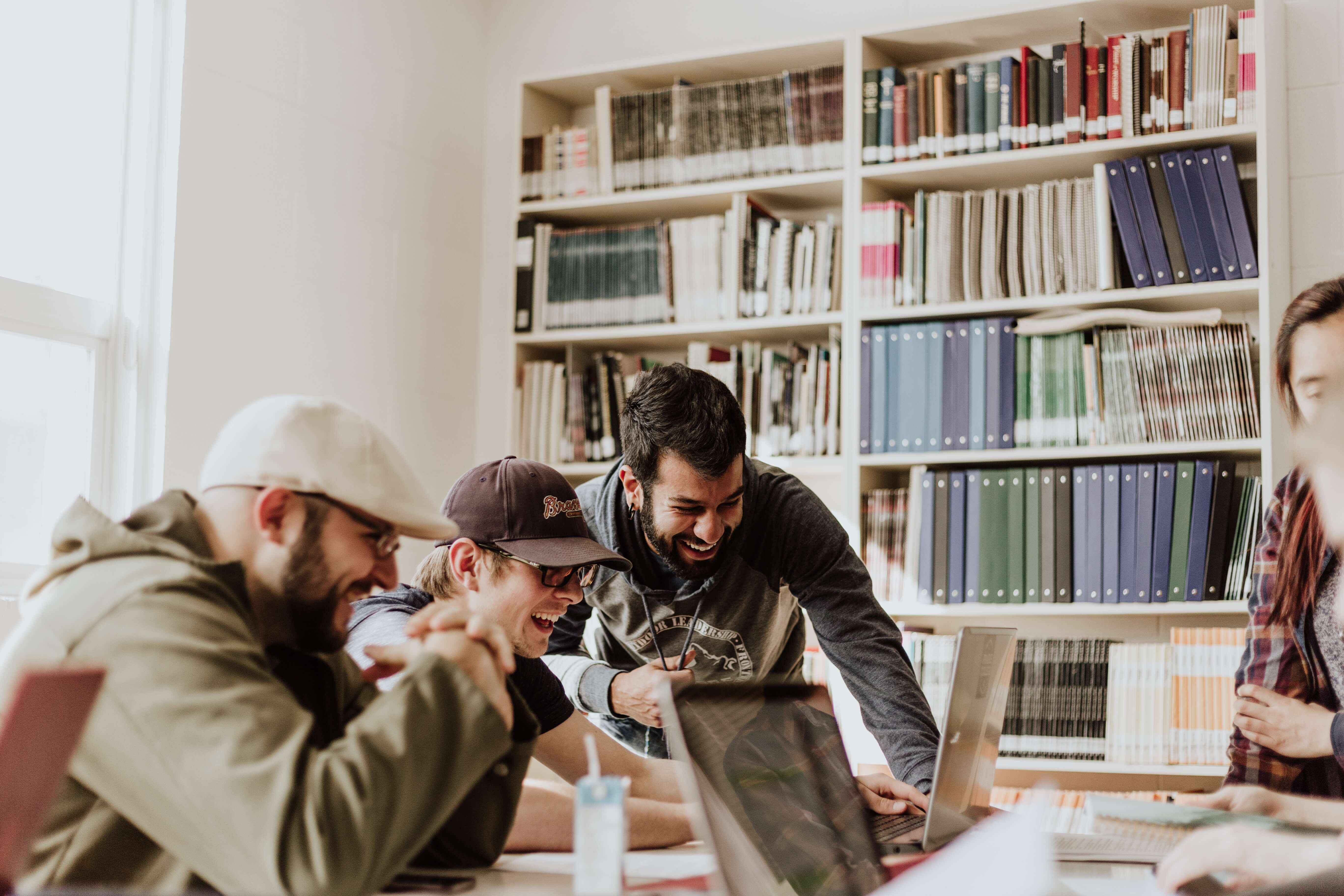 group of people working on a computer and laughing